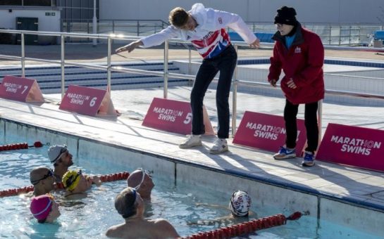 Hector Pardoe teaches some swimmers who are in the pool