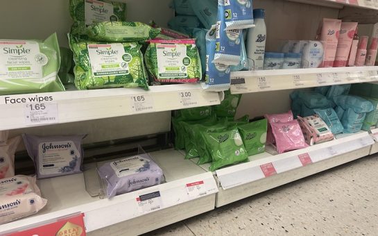 wet wipes stacked on shelves in a supermarket.