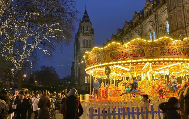 Night-time scene with a lit-up carousel and Christmas lights