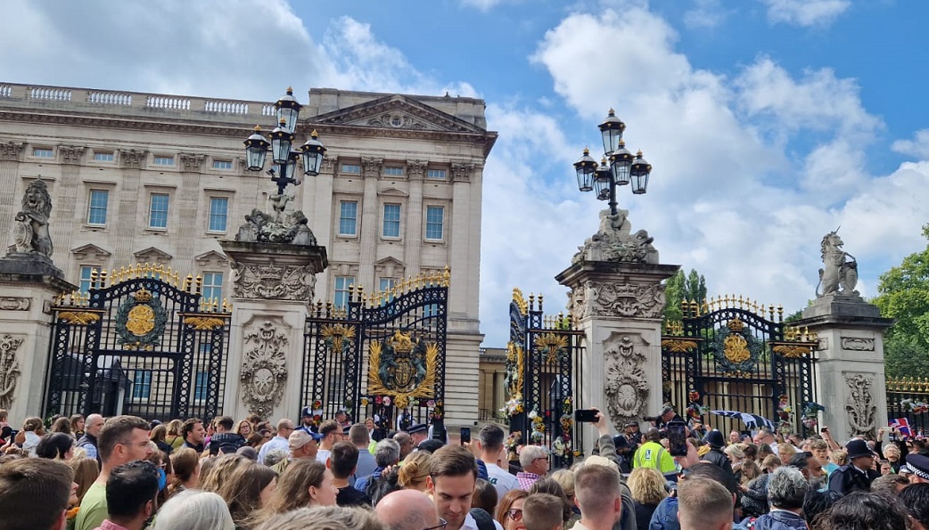 Large crowds gather outside the gates of Buckingham Palace. 