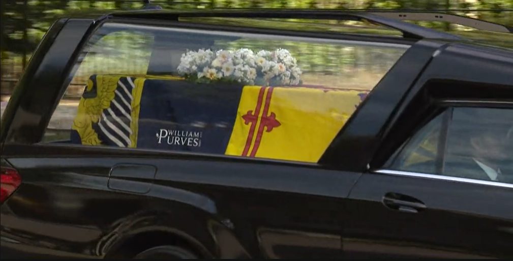 Queen Elizabeth's coffin wrapped in the Royal Standard of Scotland with a wreath of her favourite flowers from the Balmoral estate.