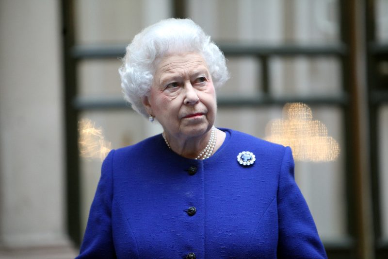 The Queen dressed in navy blue with a qhite background including black framing