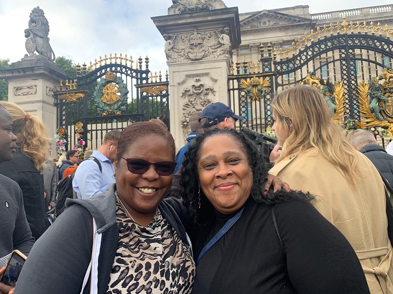 Two members of public pay tribute to the Queen outside Buckingham Palace gates