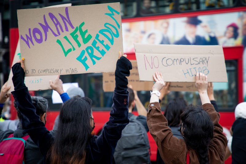 Protestors hold up cards against Iran