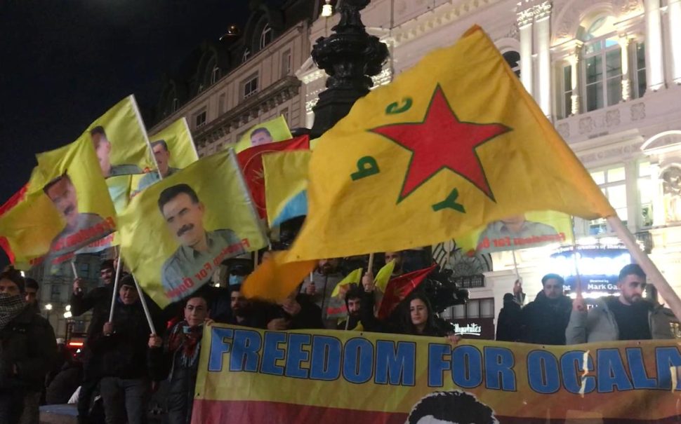 Kurdish flag with protesters