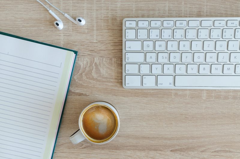 A work space with a keyboard and coffee