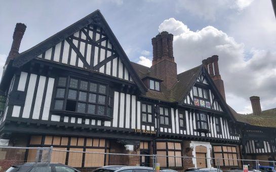 Photo of the Railway Hotel in Edgware. It is a faux Tudor building with broken and boarded up windows