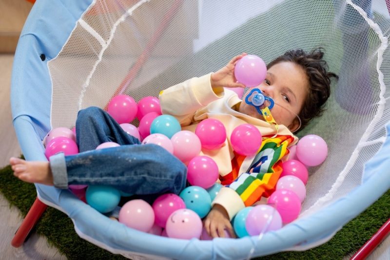 Spencer Smit, 4, at a Sense Connect and Play session. Spencer is playing with pink and blue pastic balls.