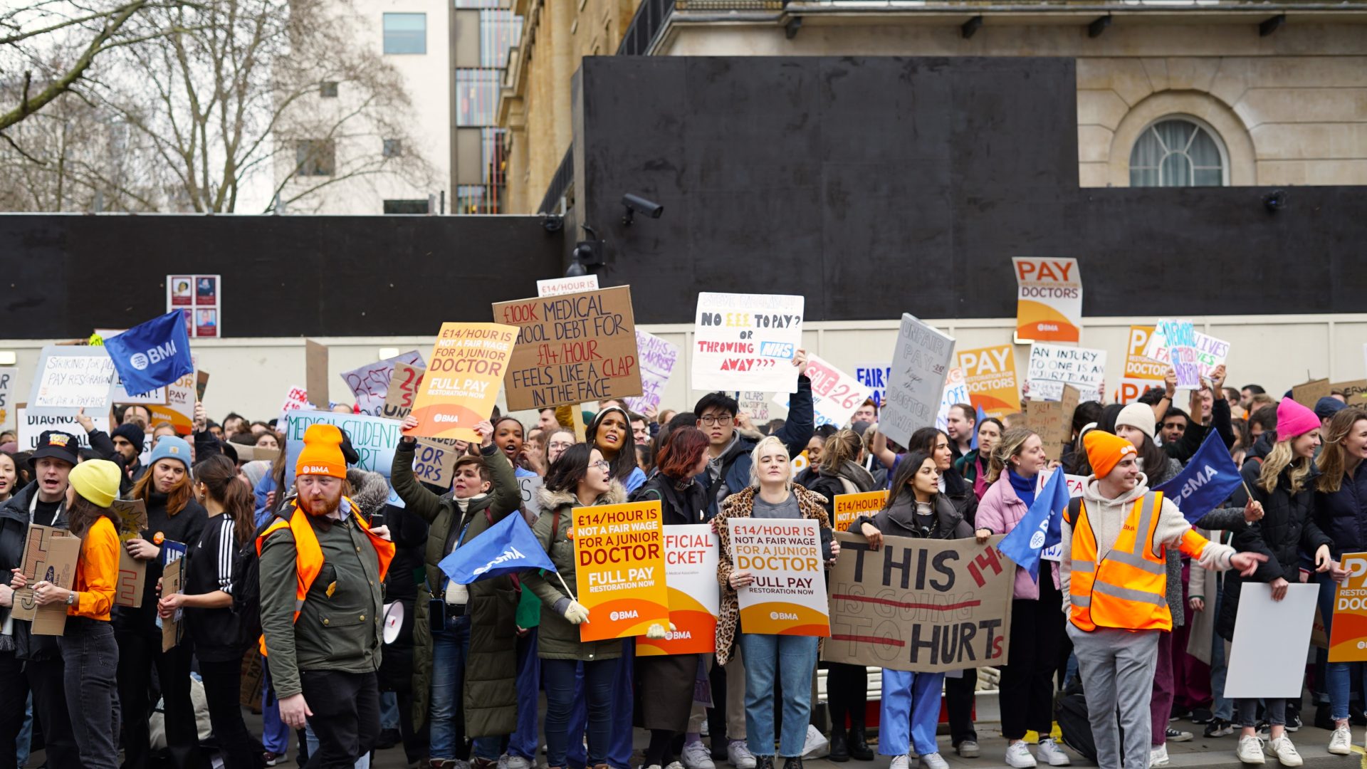 Junior doctors striking and holding up placards demanding better pay