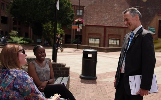 Ed Gemmell, Climate Party leader, chatting to two people sat on a bench