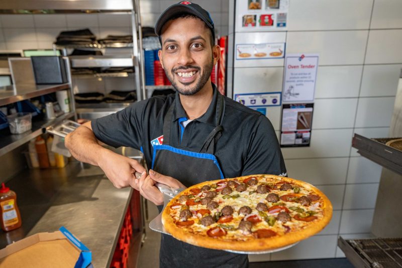 Domino's staff member with his new pizza