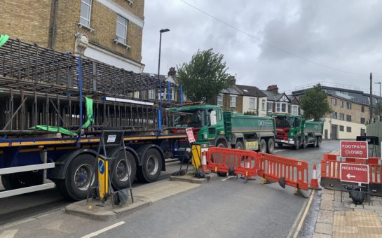 Significant construction work takes place on a road in north west London. A road closure is seen.