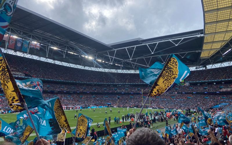 Five Jacksonville jaguars flags being flown at Wembley arena. The flags are light blue with an image of a jaguar on them.