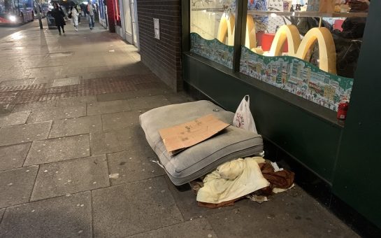 A picture of a mattress outside a fast food chain with a cardboard sign on top.