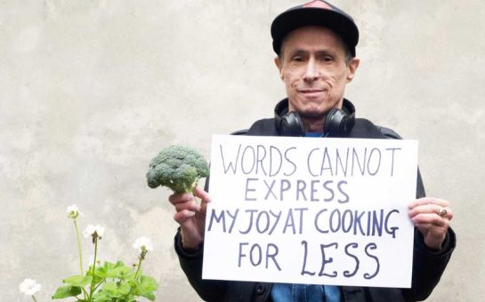 A man holding a sign saying 'Words cannot express my joy at cooking for less'