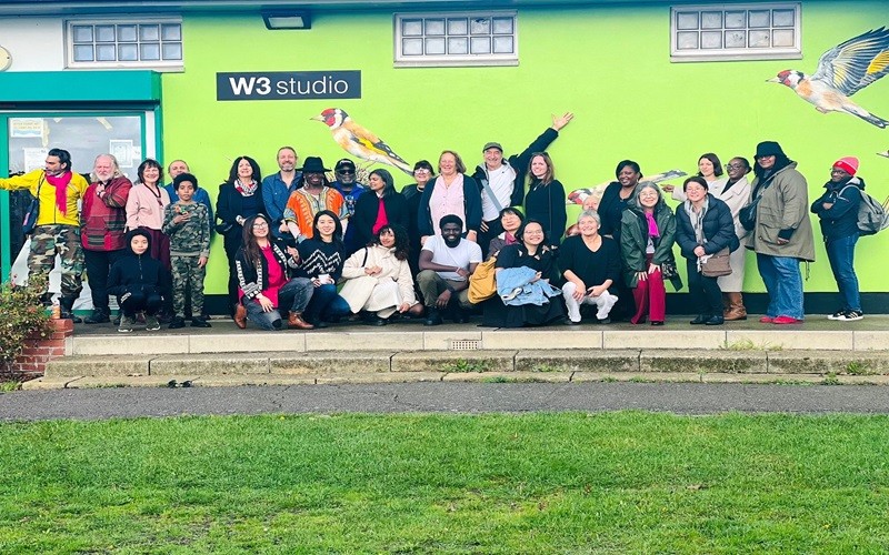 A group of people in front of a mural