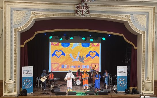 Arfoud Brothers and Sisters band performing on stage at Refugee Week event.