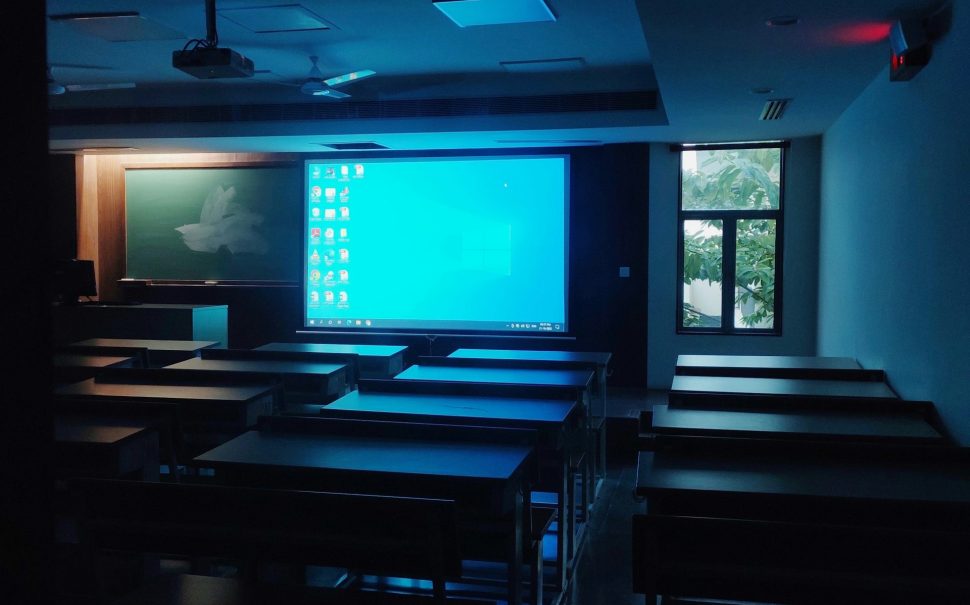 A classroom with a projector screen