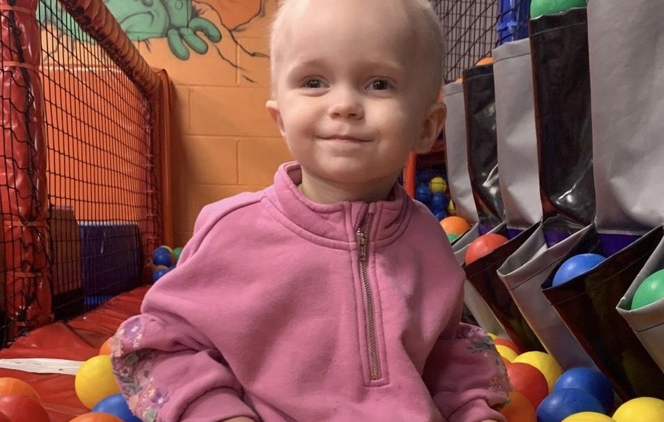 Toddler at the center of the fundraiser Lucy playing in a ball pit