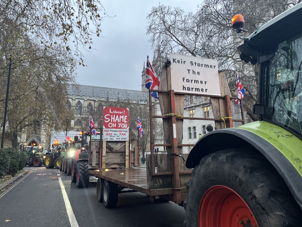 tractors line up around Parliament Square, with slogans on placards such as "Keir Starmer the farmer harmer" and "Labour! Shame on you", with Union Jack flags.