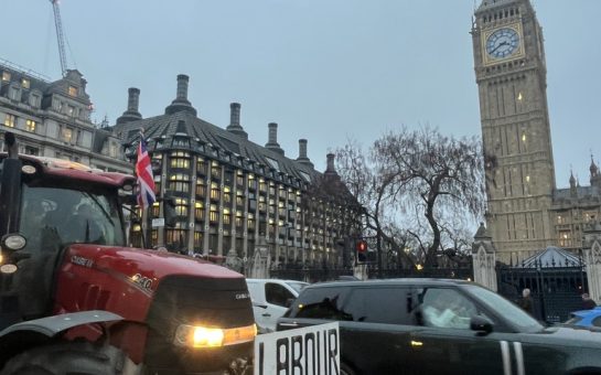 A tractor with the phrase "Labour out" is driven by Westminster