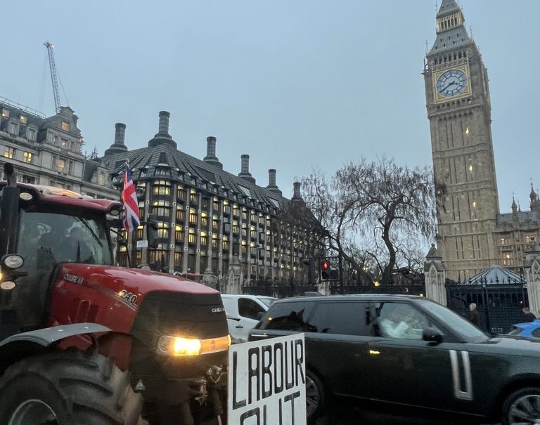 A tractor with the phrase "Labour out" is driven by Westminster