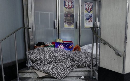 Two homeless people sleeping on the streets in Woolwich, London.