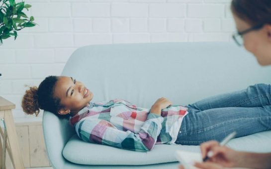 Teenager lies on sofa in discussion with her councillor