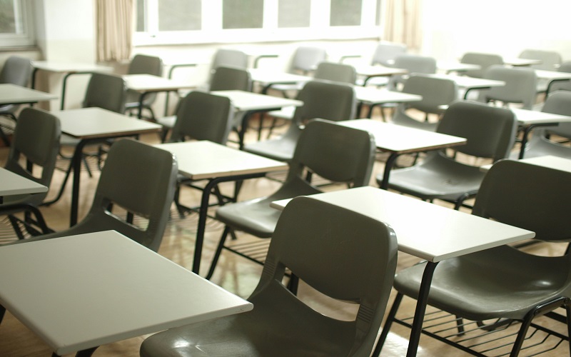 Desks and chairs in an empty school classroom.