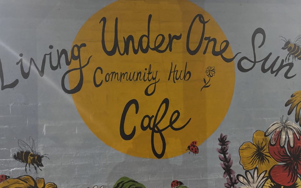 blue and yellow mural with words 'Living Under One Sun'