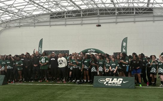This picture is of NFL star Marcelino McCrary-Ball lining up for a photo with New York Jets' NFL Girls Flag League players.