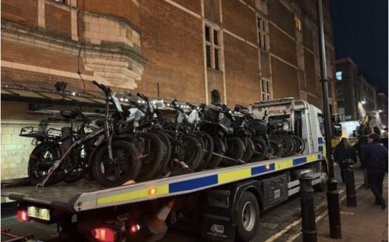Police vehicle recovery truck loaded with seized illegal e-bikes at Cambridge Circus