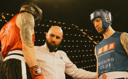 boxing umpire speaking to two boxers, one from the LFB