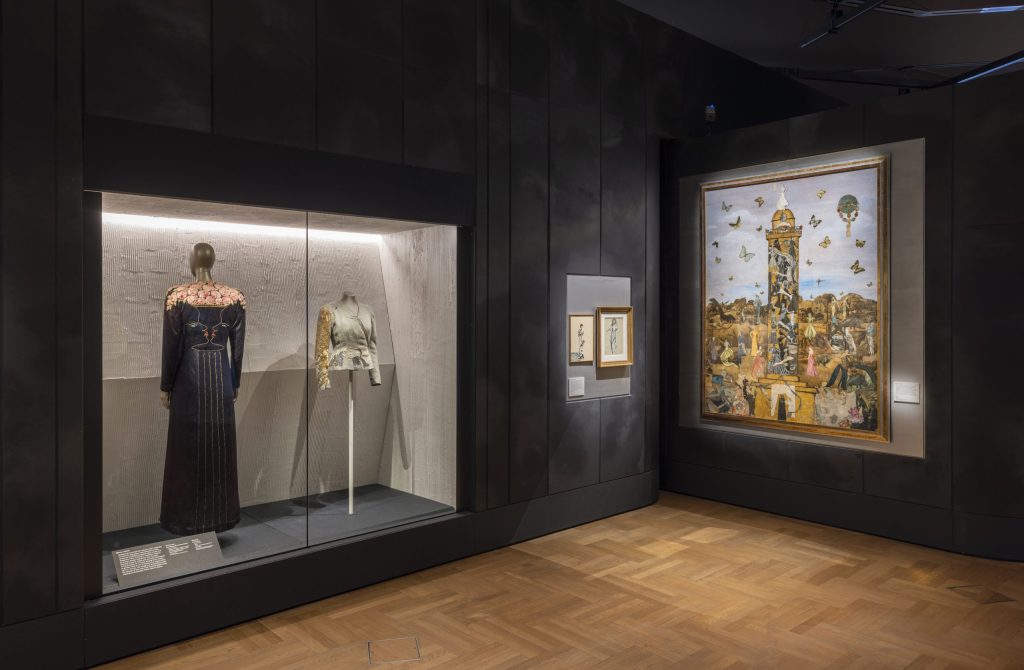 A shot of the exhibition, featuring dresses and artwork