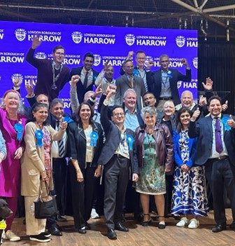 Celebrations from the Harrow Conservatives as they punch the air and smile to camera.