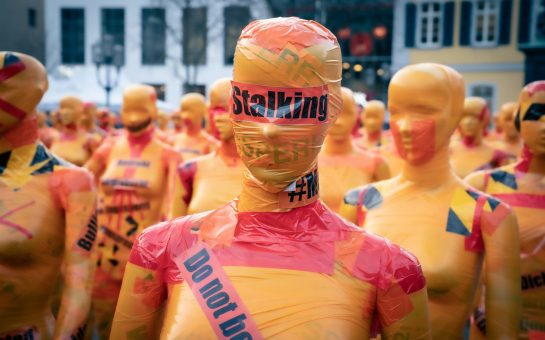 Photo of person in tape with stalking labelling across them