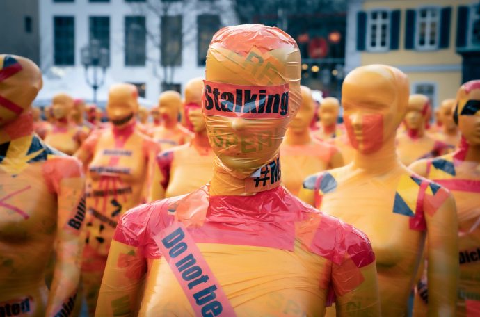 Photo of person in tape with stalking labelling across them