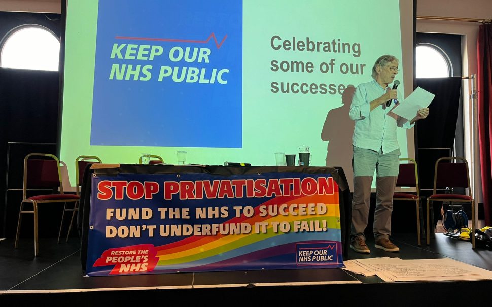 A man is speaking at a conference held by NHS campaigners.