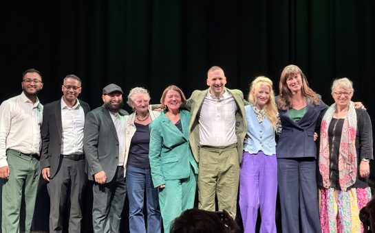Green Party Leader Zack Polanskio on stage in a group photo with his party