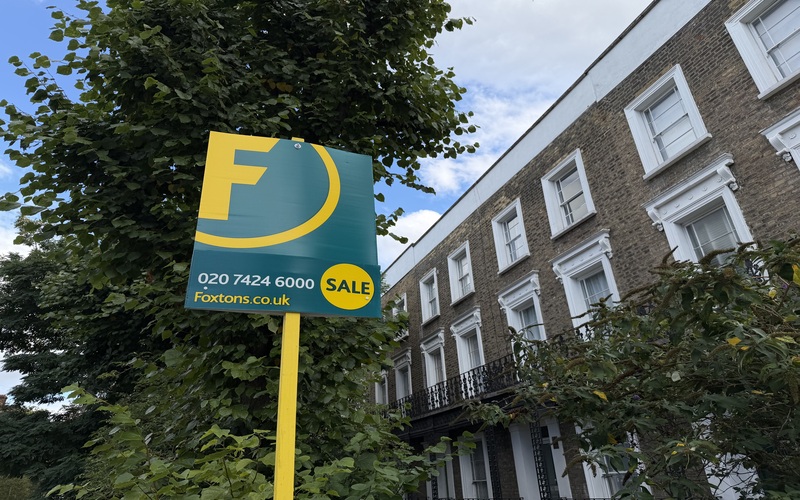Foxtons "For Sale" sign beside brick townhouses in Holborn and St Pancras, London.