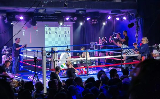 Two men playing chess in a boxing ring