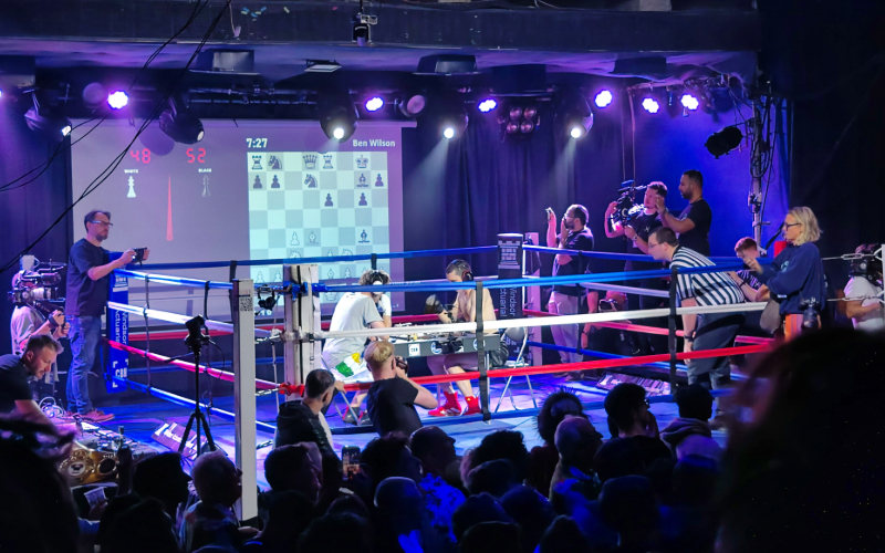 Two men playing chess in a boxing ring